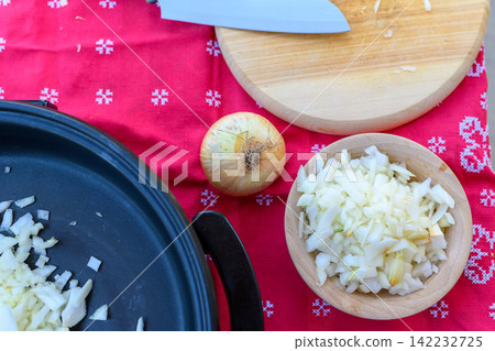 Thin slices of raw fresh onions in white wooden bowl 142232725