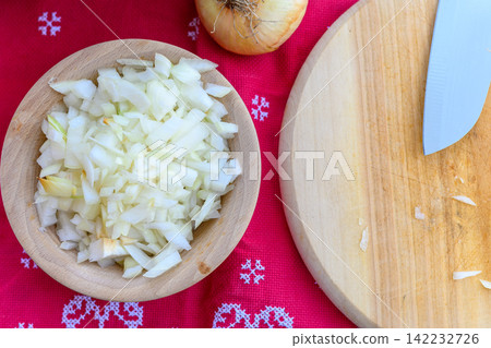 Thin slices of raw fresh onions in white wooden bowl Thin slices of raw fresh onions in white wooden bowl 142232726