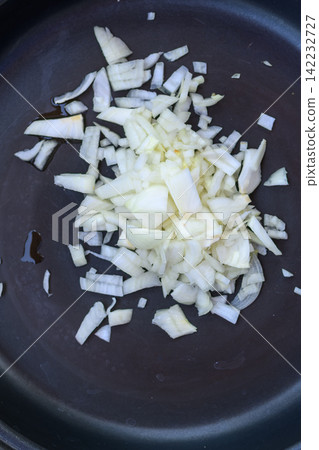 Top view of fresh diced onion on a cooking pan 142232727