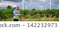 Engineer surveys wind farm in open field 142232973