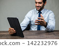 Man smiles while holding a tablet6 | 33 142232976