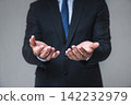 Businessman stands with hands open, palms up 142232979