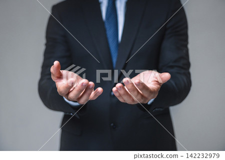 Businessman stands with hands open, palms up 142232979