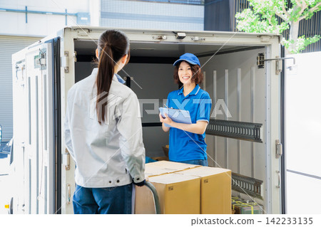 Female driver and worker loading trucks 142233135