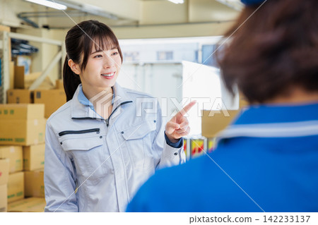 Women working in work clothes in a warehouse Women working in work clothes in a warehouse 142233137