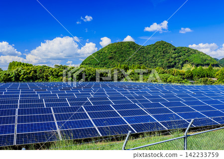 A vast solar power plant (mega solar) with a clear blue sky and midsummer clouds. A vast solar power plant (mega solar) with a clear blue sky and midsummer clouds. 142233759