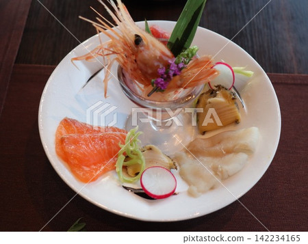 A luxurious Japanese dish featuring a platter of sweet shrimp and salmon sashimi. A luxurious Japanese dish featuring a platter of sweet shrimp and salmon sashimi. 142234165