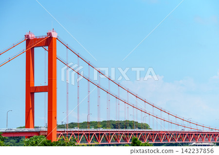 The red bridge (Hirado Bridge) stands out against the blue sky and green mountain range. The red bridge (Hirado Bridge) stands out against the blue sky and green mountain range. 142237856