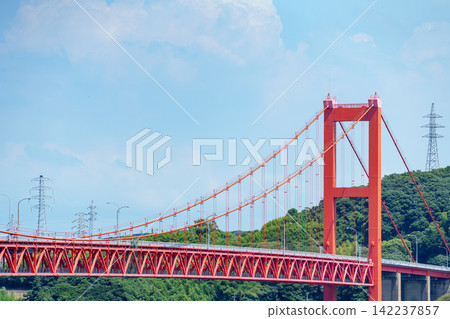 The red bridge (Hirado Bridge) stands out against the blue sky and green mountain range. The red bridge (Hirado Bridge) stands out against the blue sky and green mountain range. 142237857
