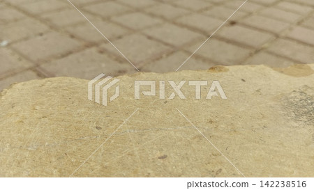 Close up edge of yellow stone slab on paved ground stock photo, natural rock material texture background macro detail Close up edge of yellow stone slab on paved ground stock photo, natural rock material texture background macro detail 142238516