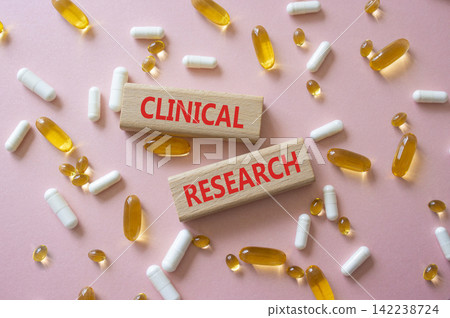 CLINICAL RESEARCH symbol. Concept word CLINICAL RESEARCH on wooden blocks. Beautiful pink background with pills. Medicine and CLINICAL RESEARCH. Copy space CLINICAL RESEARCH symbol. Concept word CLINICAL RESEARCH on wooden blocks. Beautiful pink background with pills. Medicine and CLINICAL RESEARCH. Copy space 142238724