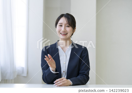 A smiling businesswoman in her 30s speaks while looking directly at the camera. A smiling businesswoman in her 30s speaks while looking directly at the camera. 142239023