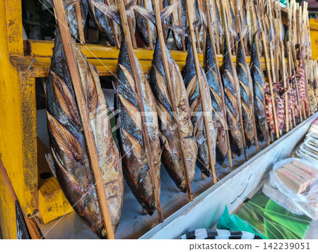 Smoked fish skewered on bamboo sticks served on paper wrapping at a local street stall in Trenggalek, East Java. Smoked fish skewered on bamboo sticks served on paper wrapping at a local street stall in Trenggalek, East Java. 142239051
