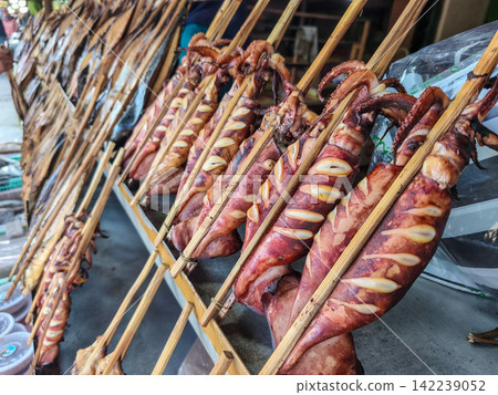 Smoked fish skewered on bamboo sticks served on paper wrapping at a local street stall in Trenggalek, East Java. Smoked fish skewered on bamboo sticks served on paper wrapping at a local street stall in Trenggalek, East Java. 142239052