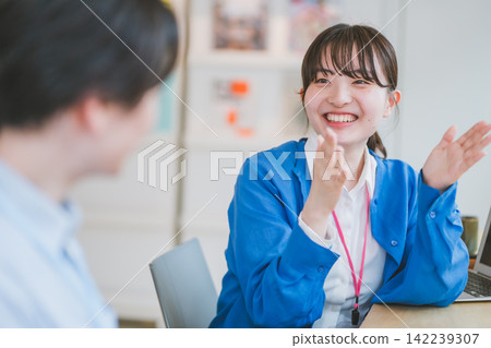 Office scene of a woman talking to a colleague using gestures and body language. Office scene of a woman talking to a colleague using gestures and body language. 142239307