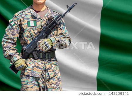 Nigeria flag with soldier holding assault rifle Nigeria flag with soldier holding assault rifle 142239341