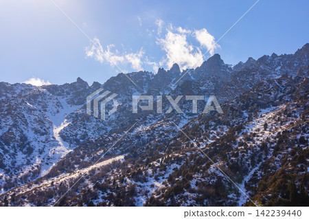 Snow-Covered Mountain Range in Kyrgyzstan Under Blue Sky Snow-Covered Mountain Range in Kyrgyzstan Under Blue Sky 142239440