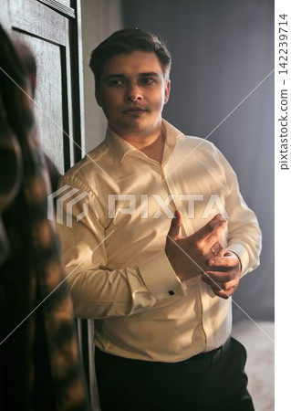 Young Asian male showcases stylish outfit in classic interior setting Young Asian male showcases stylish outfit in classic interior setting 142239714