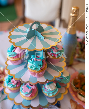Gender reveal party cupcakes on a stand pink and blue colors Gender reveal party cupcakes on a stand pink and blue colors 142239811