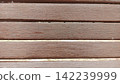 Straight on close up framing horizontal brown painted wooden slats of an outdoor park bench perfect for wooden backgrounds 142239999