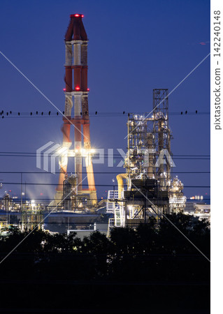 The red and white chimneys of a factory towering over the night in Ichihara City, Chiba Prefecture. The red and white chimneys of a factory towering over the night in Ichihara City, Chiba Prefecture. 142240148