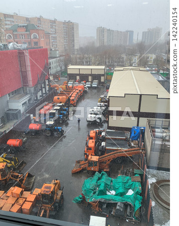 High angle view of a construction site with heavy machinery parked in a snowy urban environment High angle view of a construction site with heavy machinery parked in a snowy urban environment 142240154