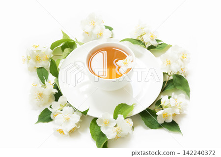 Jasmine flowers around cup of green tea on white background. Teatime. Jasmine flowers around cup of green tea on white background. Teatime. 142240372