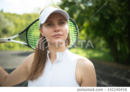 Female tennis player portrait with racket on outdoor court Female tennis player portrait with racket on outdoor court 142240438