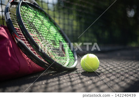 Tennis racket and ball on court with sports bag Tennis racket and ball on court with sports bag 142240439