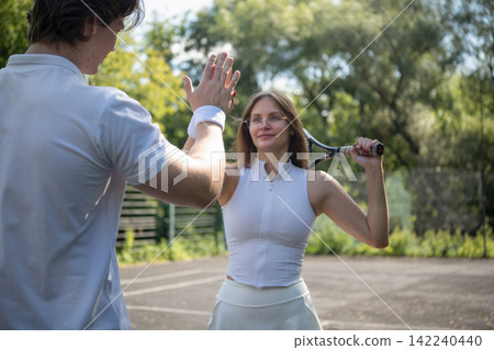 Tennis players giving high five during outdoor training Tennis players giving high five during outdoor training 142240440