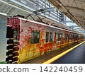 The light reflected from the cherry blossom and deer-themed train casts a yellow line on the station platform. 142240459