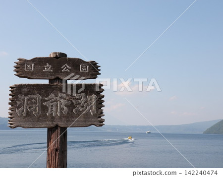 洞爺湖國家公園的標誌牌和一艘在湖上航行的機動船。 142240474