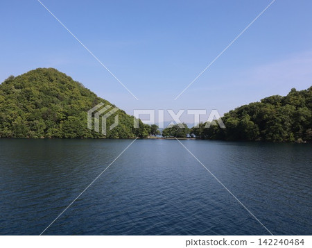 一條靜謐的水道,靜躺在島嶼與海岬之間;湖光山色,綠樹環繞。 一條靜謐的水道,靜躺在島嶼與海岬之間;湖光山色,綠樹環繞。 142240484