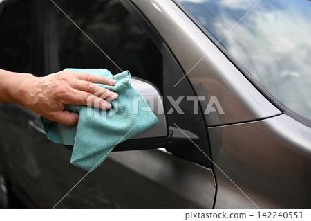 Cleaning car side mirror with microfiber cloth by hand Cleaning car side mirror with microfiber cloth by hand 142240551