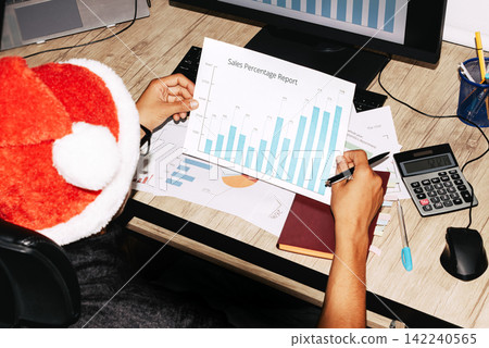 Overhead view of person analyzing bar chart during festive season Overhead view of person analyzing bar chart during festive season 142240565