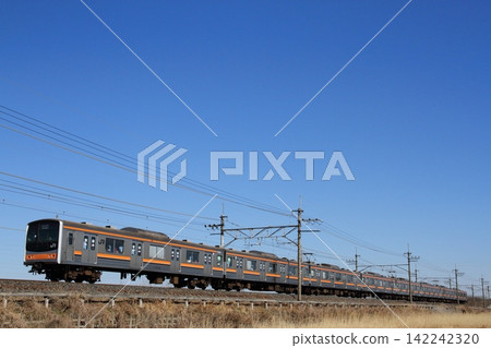 一列外型如童話般的205系列車在藍天下沿著武藏野線行駛。 一列外型如童話般的205系列車在藍天下沿著武藏野線行駛。 142242320