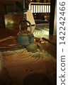 An iron kettle hanging in the hearth 142242466