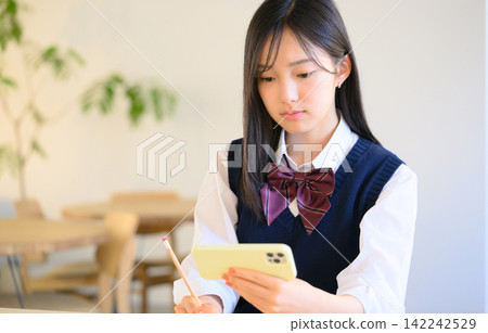 School girls watching smartphone School girls watching smartphone 142242529
