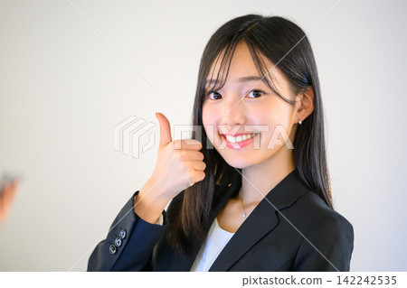 辦公室裡,一名女員工豎起大拇指,面帶微笑。 辦公室裡,一名女員工豎起大拇指,面帶微笑。 142242535