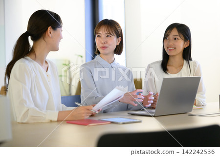 Three women discussing at a meeting Three women discussing at a meeting 142242536