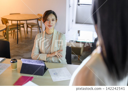 一位女商務人士正在辦公室開會。 142242541