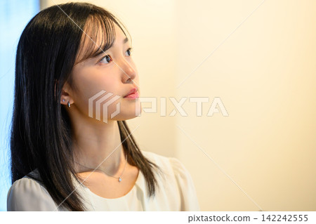 辦公室裡的一位女員工抬起頭,陷入沉思。 辦公室裡的一位女員工抬起頭,陷入沉思。 142242555