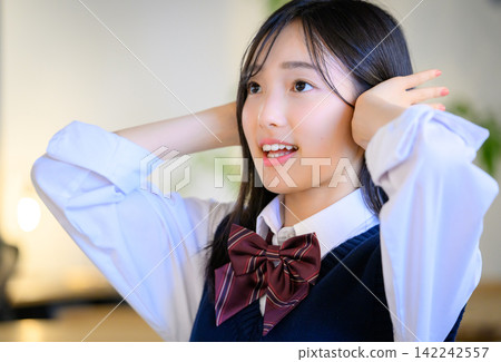 一位高中女生整理了一下頭髮,露出了笑容。 一位高中女生整理了一下頭髮,露出了笑容。 142242557
