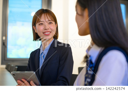 Business professionals and students having a meeting using tablets. Business professionals and students having a meeting using tablets. 142242574
