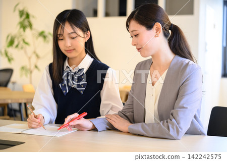A scene of a teacher instructing a student in a private tutoring session. A scene of a teacher instructing a student in a private tutoring session. 142242575