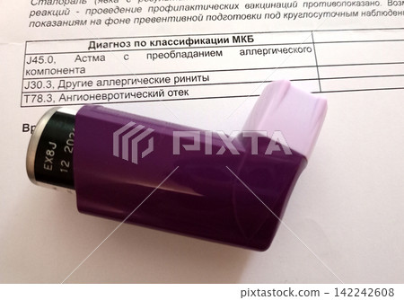 An asthma inhaler with an expiration date on the bottle and a medical report with a diagnosis An asthma inhaler with an expiration date on the bottle and a medical report with a diagnosis 142242608