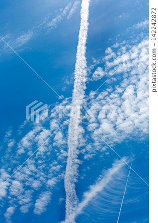 Contrails in the sky during the rainy season; blue sky and clouds. Contrails in the sky during the rainy season; blue sky and clouds. 142242872