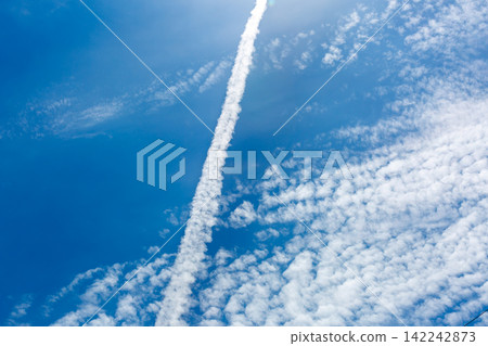 Contrails in the sky during the rainy season; blue sky and clouds. Contrails in the sky during the rainy season; blue sky and clouds. 142242873