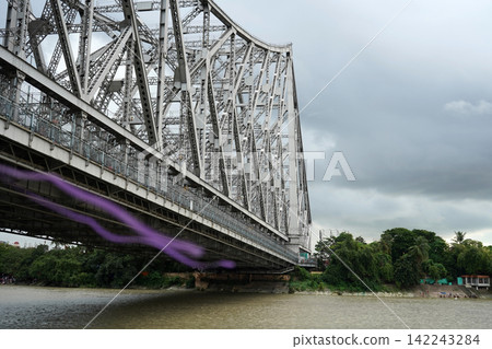 Close up view of Howrah Bridge steel structure over Hooghly River under cloudy sky in Kolkata Close up view of Howrah Bridge steel structure over Hooghly River under cloudy sky in Kolkata 142243284