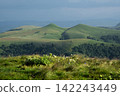 Rolling Green Hills and Mountain Landscape in Daylight 142243449